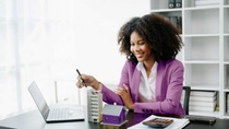 Jeune femme assise à son bureau à regarder de petits modèles de bâtiments. Jeune femme assise à son bureau à regarder de petits modèles de bâtiments.