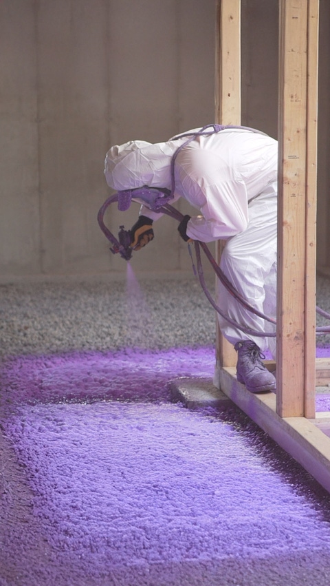 Installer applying WALLTITE purple spray foam to gravel as an under slab radon barrier. Installer applying WALLTITE purple spray foam to gravel as an under slab radon barrier.