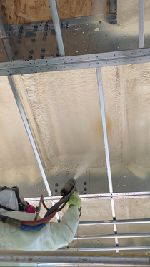 Image of our BASF Closed-cell Spray Polyurethane Foam being sprayed overhead in a commercial building