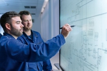 Two people looking at a manufacturing system dashboard
