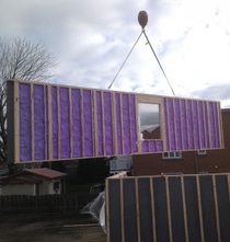 An HP+ Wall System being lifted at a residential construction site.