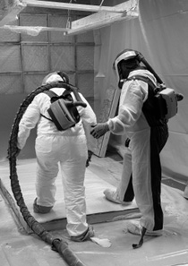 Two people applying spray foam to a substrate Two people applying spray foam to a substrate